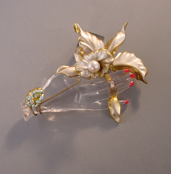 LUCITE jelly belly trembler brooch, a hand holding an orchid