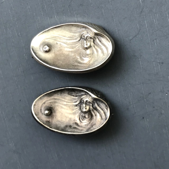 ART NOUVEAU set of two miniature sterling silver oyster pins, each with a woman’s face and a raised silver “pearl” in it