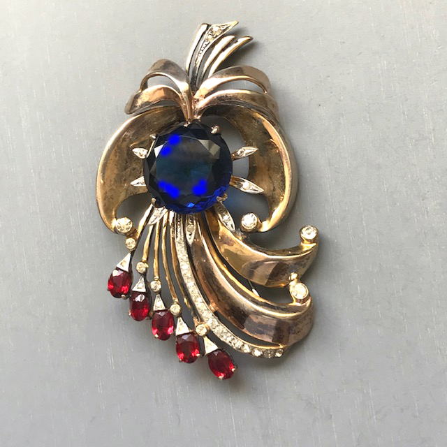 DEROSA fur clip with a deep blue round faceted center rhinestone and red and clear rhinestones all in a gold washed setting