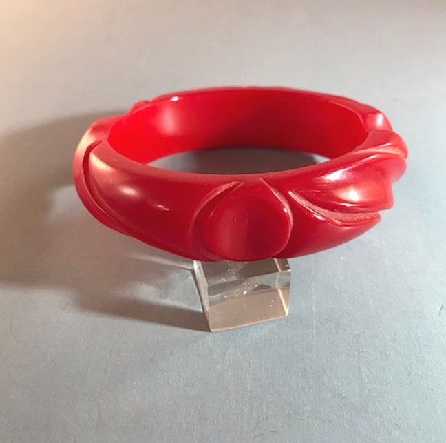 BAKELITE red bangle with leaf and thumbprint carved designs