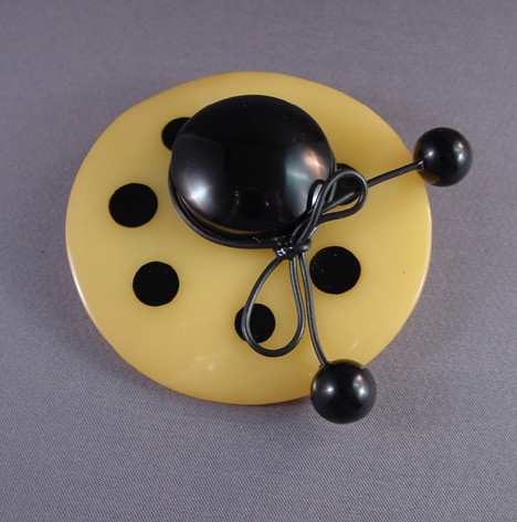 SHULTZ bakelite yellow hat brooch with black dots, tie and crown