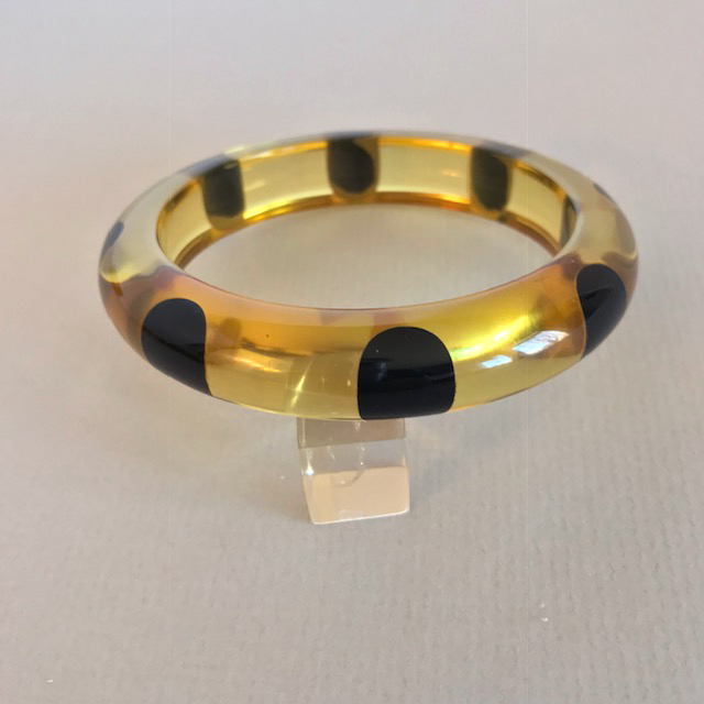 SHULTZ bakelite bangle in apple juice with 8 black dots around it